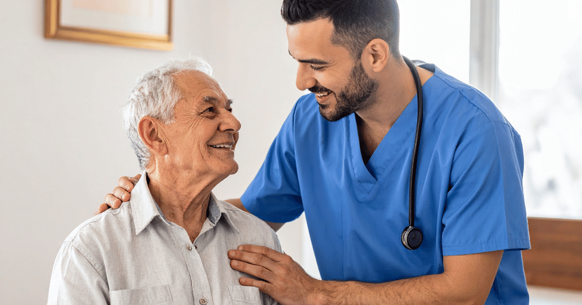 An elderly patient smiles up at a medical staff member. Photo by truecreatives, sourced from Canva.